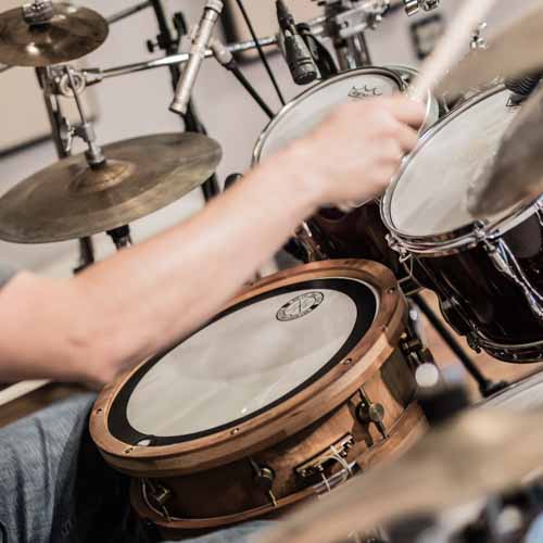 Professional drummer playing Partido Alto Brazilian groove on drumset